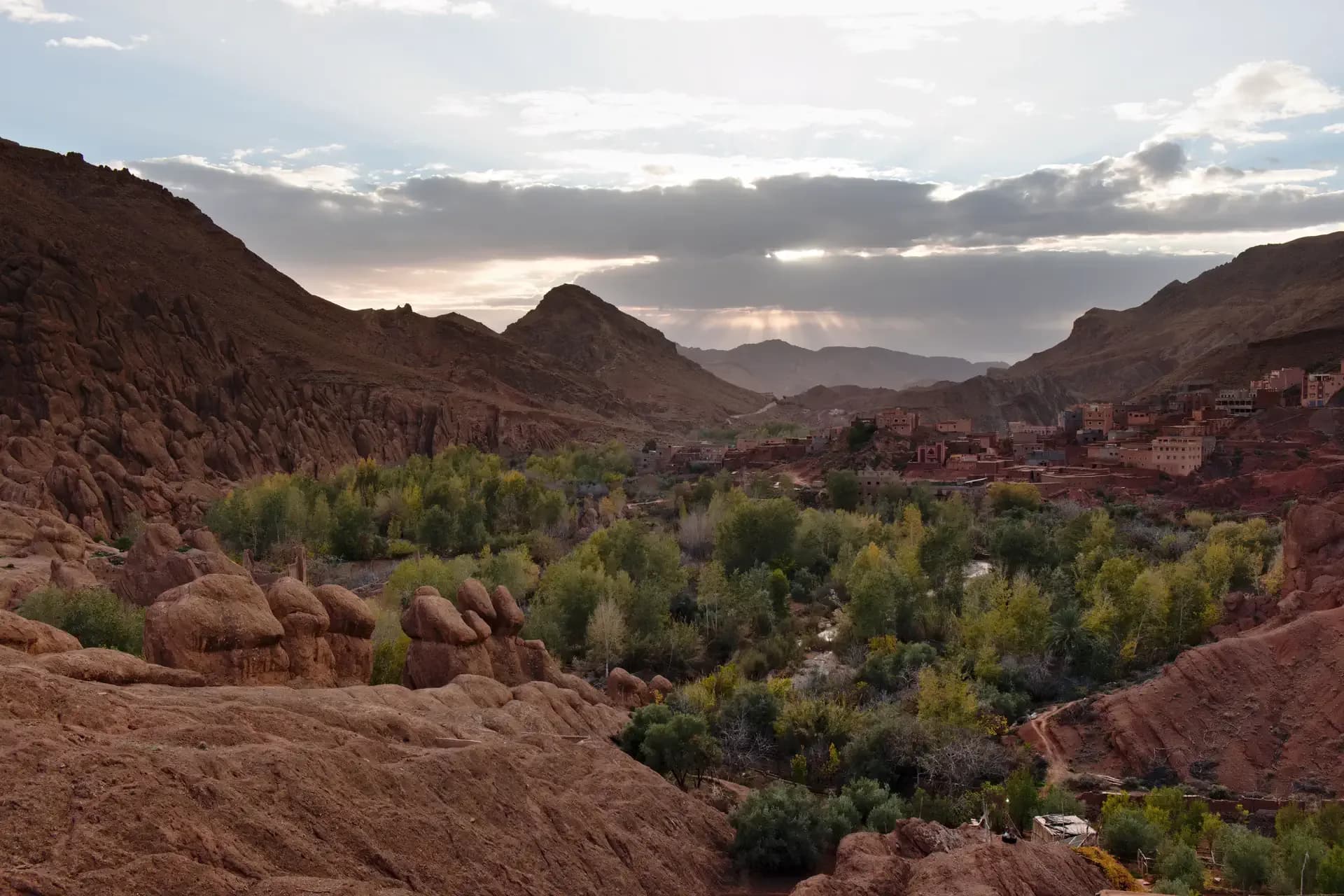 Evening light over the Dades valley: red rock, poplars and a kasbah village